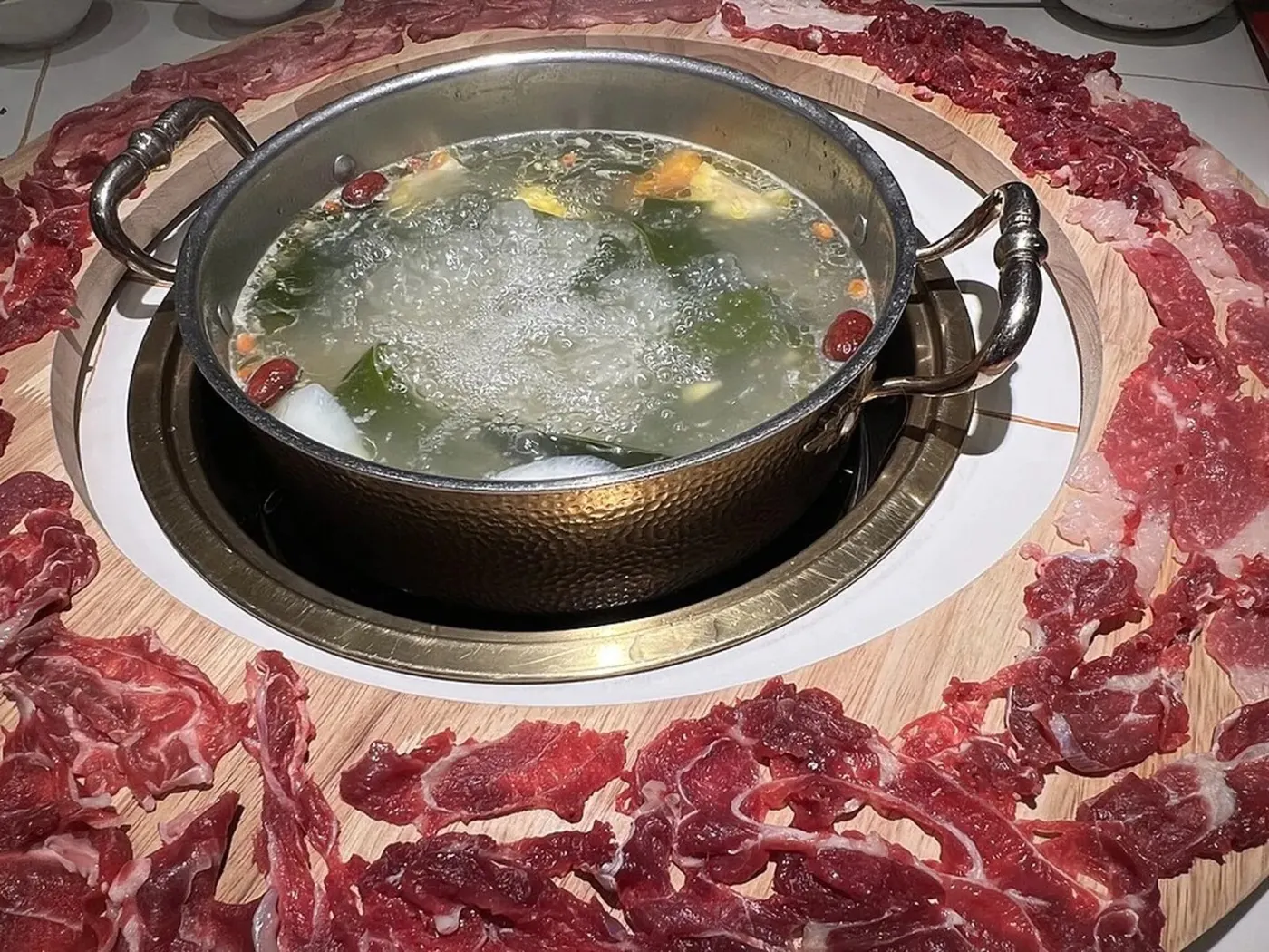 清汤牛肉火锅,锅边摆满现切的生牛肉片