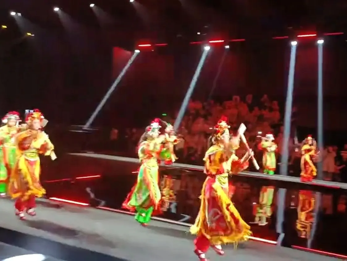 舞台上灯光压成红色,一队人正在演