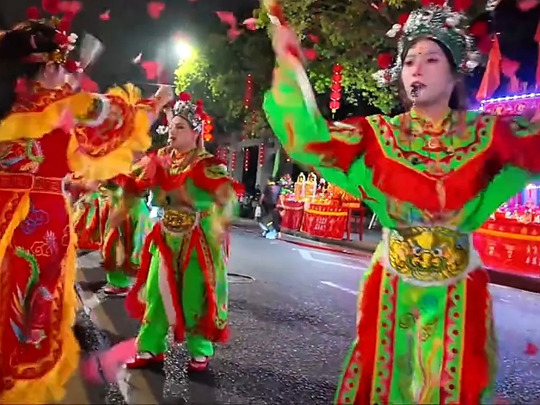 夜里街面巡游，队员着彩衣列队
