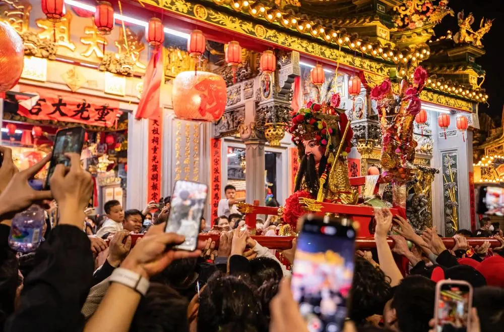 老爷神轿前,人群举手机拍摄