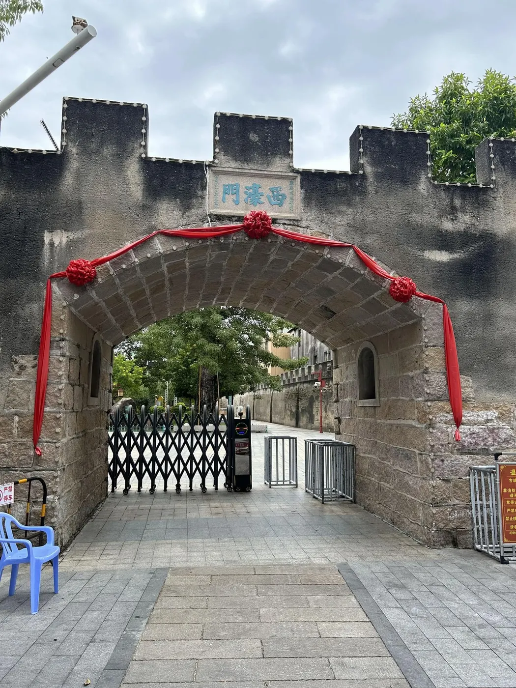 石砌门洞与城垛,门额题「西濠门」,门上系红绸
