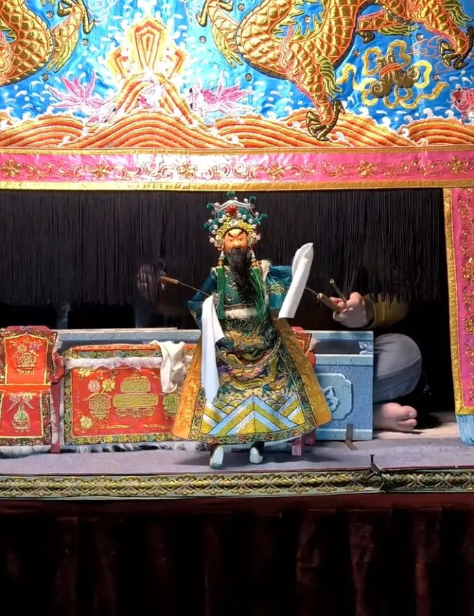 铁枝木偶戏台正面:绿袍木偶立于台口,台后可见操偶的手