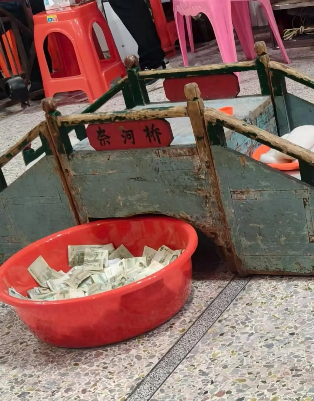 法事上用的纸扎桥,桥头牌上写着「奈河桥」,前面的红盆装着纸钱。图源:抖音 @Chenkai,2025 年 9 月 7 日。