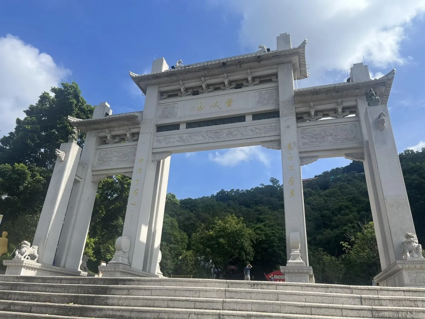 三间四柱的石牌坊,后面是青山与蓝天
