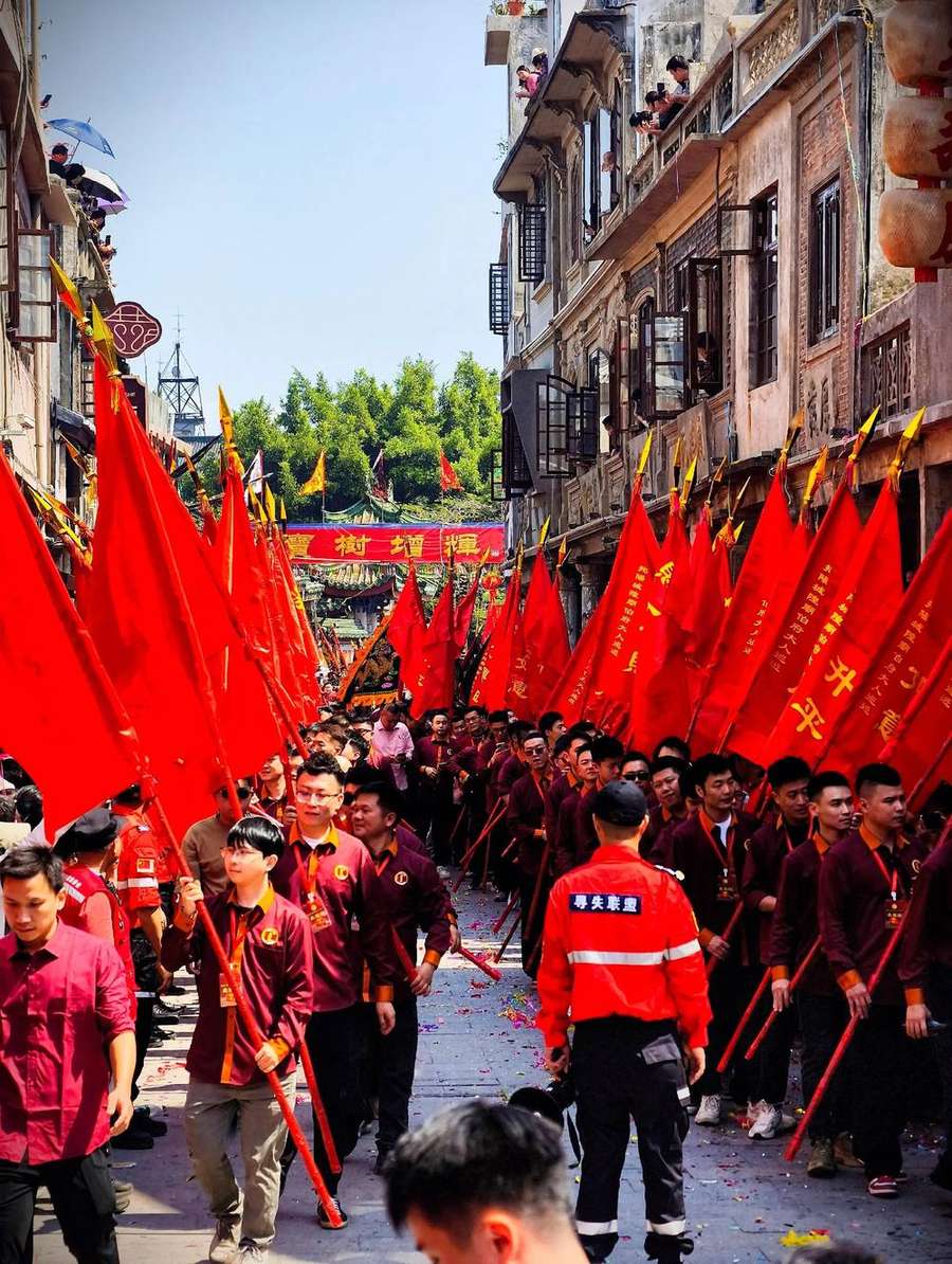 红旗成阵,队伍沿骑楼街前行