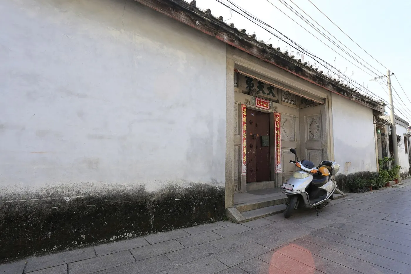巷口:石板路、排水明沟、墙基的石脚,全在一条窄巷里。Zhangzhugang 摄,CC BY-SA 4.0,Wikimedia Commons。