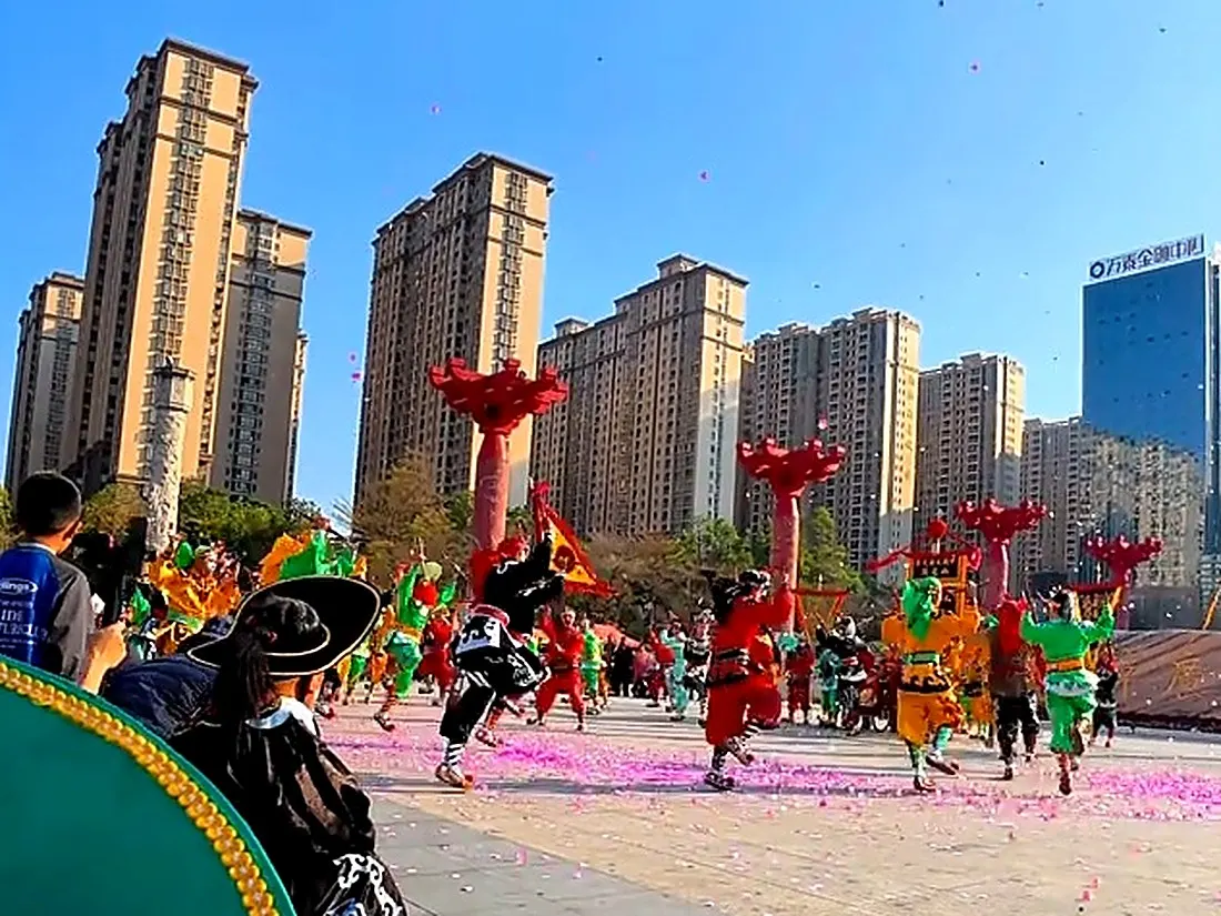 广场上队伍散开，背景是成排高楼