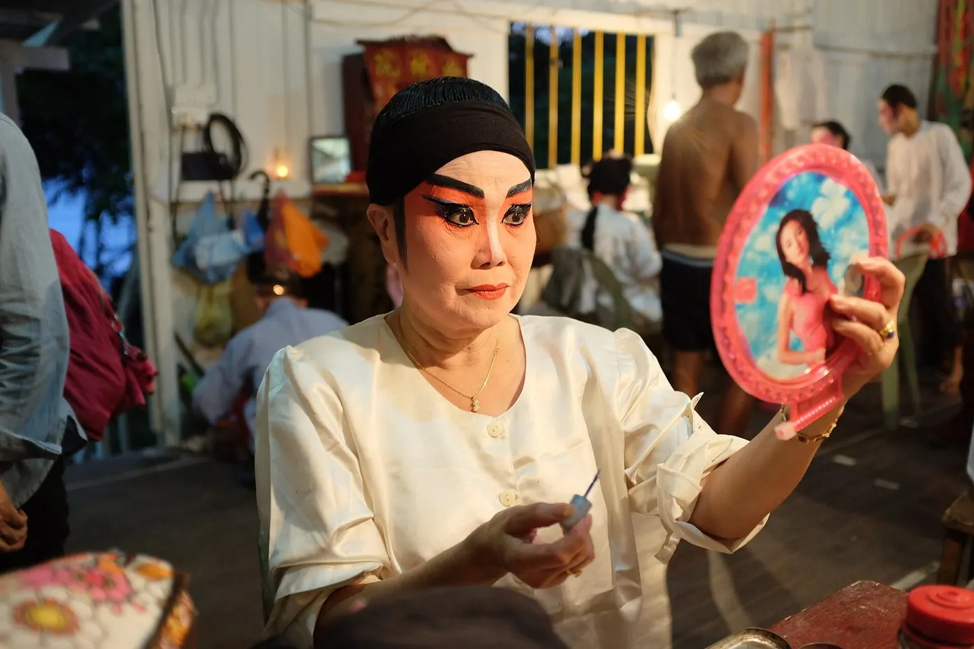 潮剧演员在后台对镜补妆，已勾好脸谱
