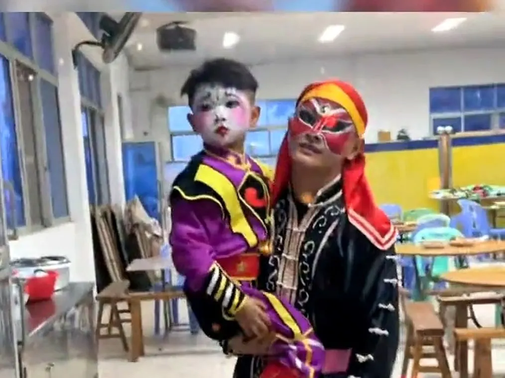 勾脸的队员抱起一个穿队服的小孩