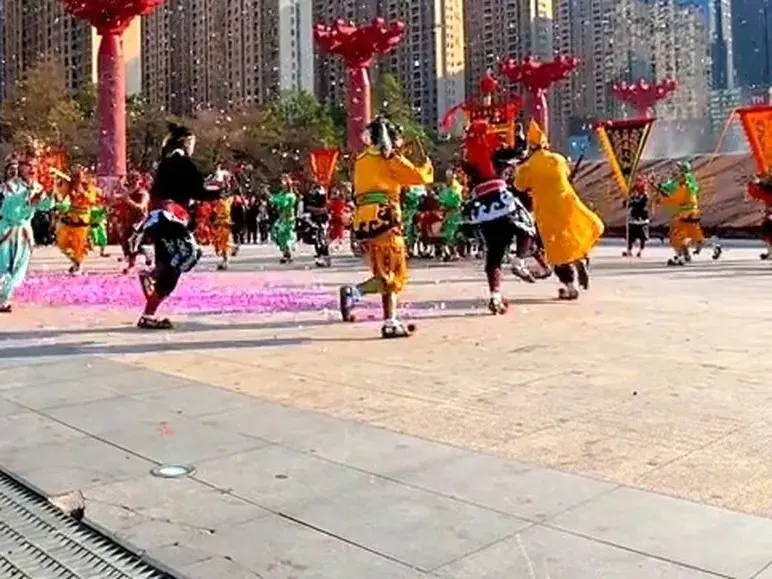 广场上队员散开,红柱彩纸,背景是成排高楼
