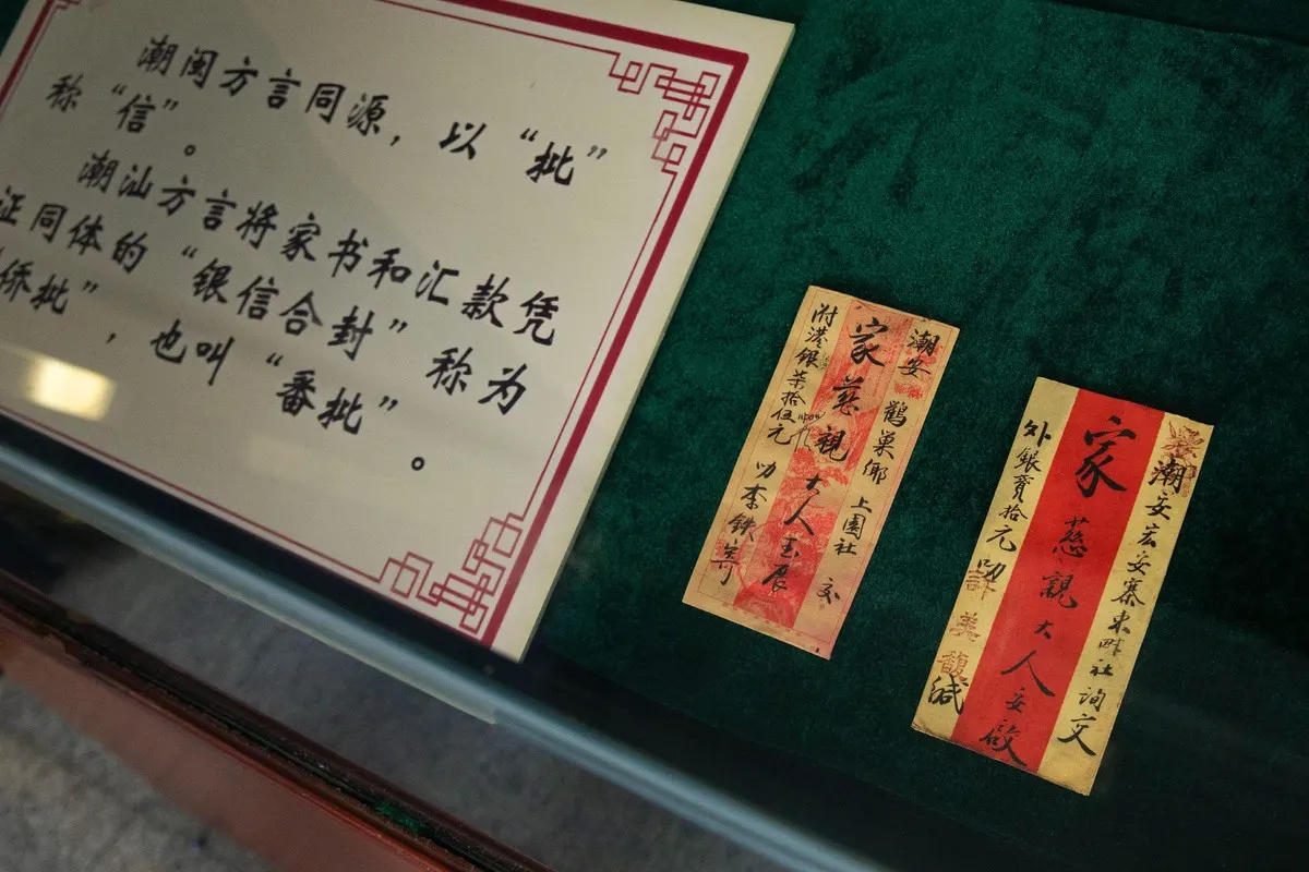 展柜内一块说明牌,旁列两封竖排侨批,绿绒衬底