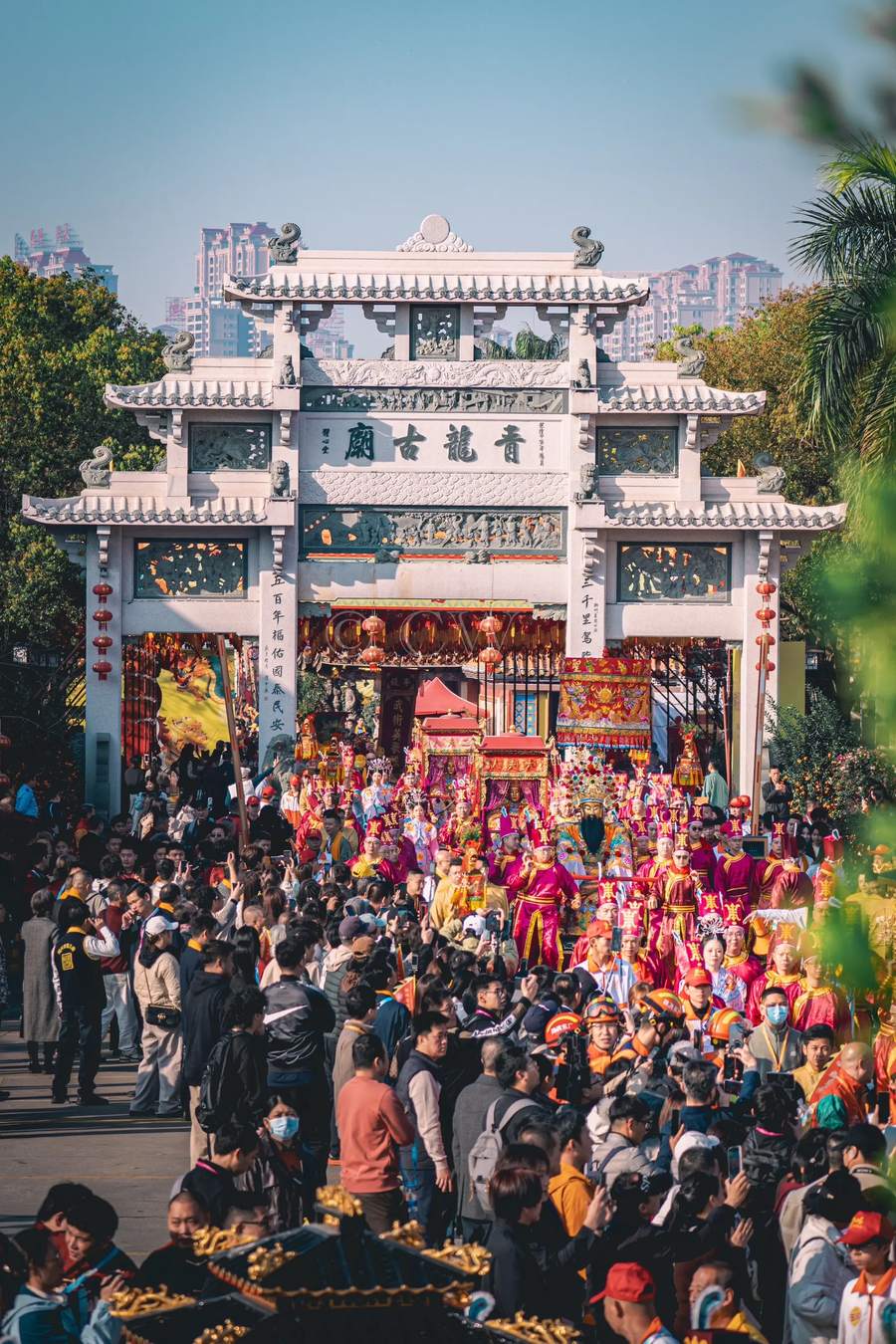 石牌坊前队伍经过，两侧站满人