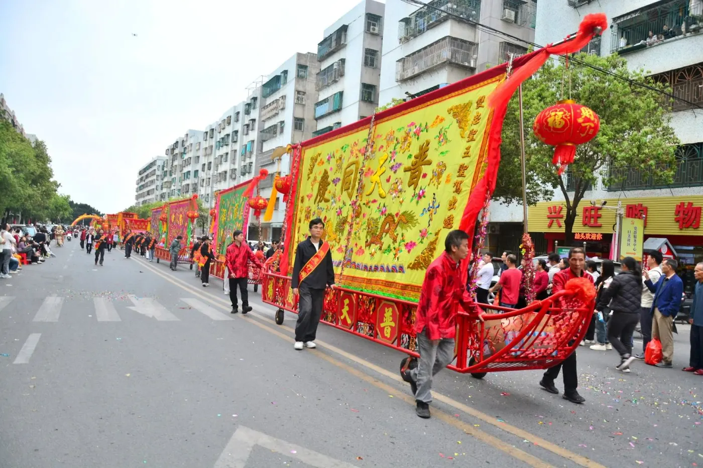 巡游队伍抬着大幅标旗