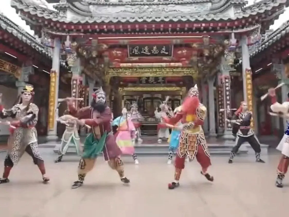 庙前天井，一队人在演，门楣匾额横在梁上