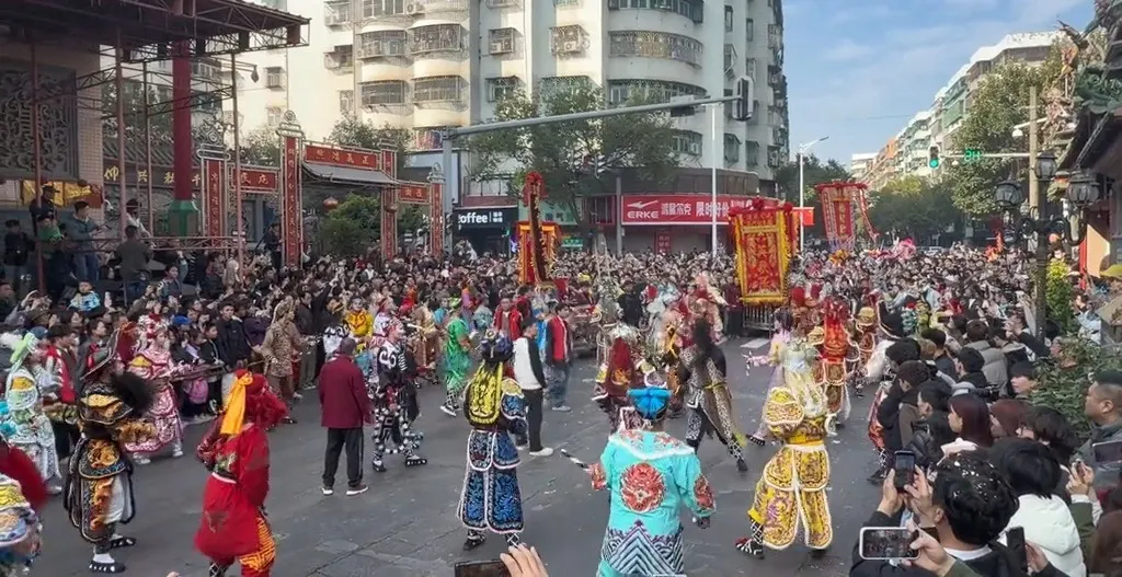 街口立着牌楼与红色横幅，队伍从牌楼下经过，两侧站满观众