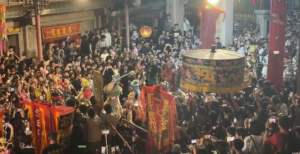 夜里的庙门前，一面彩绘大鼓架在人堆里，两旁立着红旗