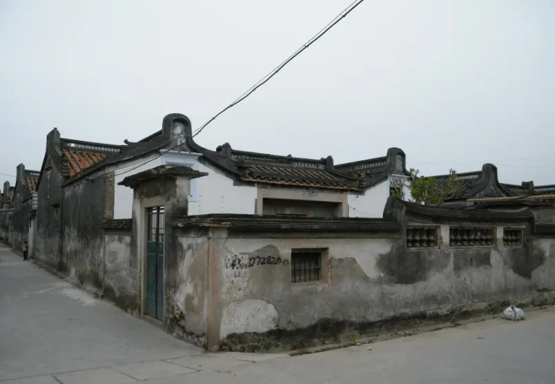 一座下山虎的外墙与门楼，院墙围出前院，山墙顶起翘