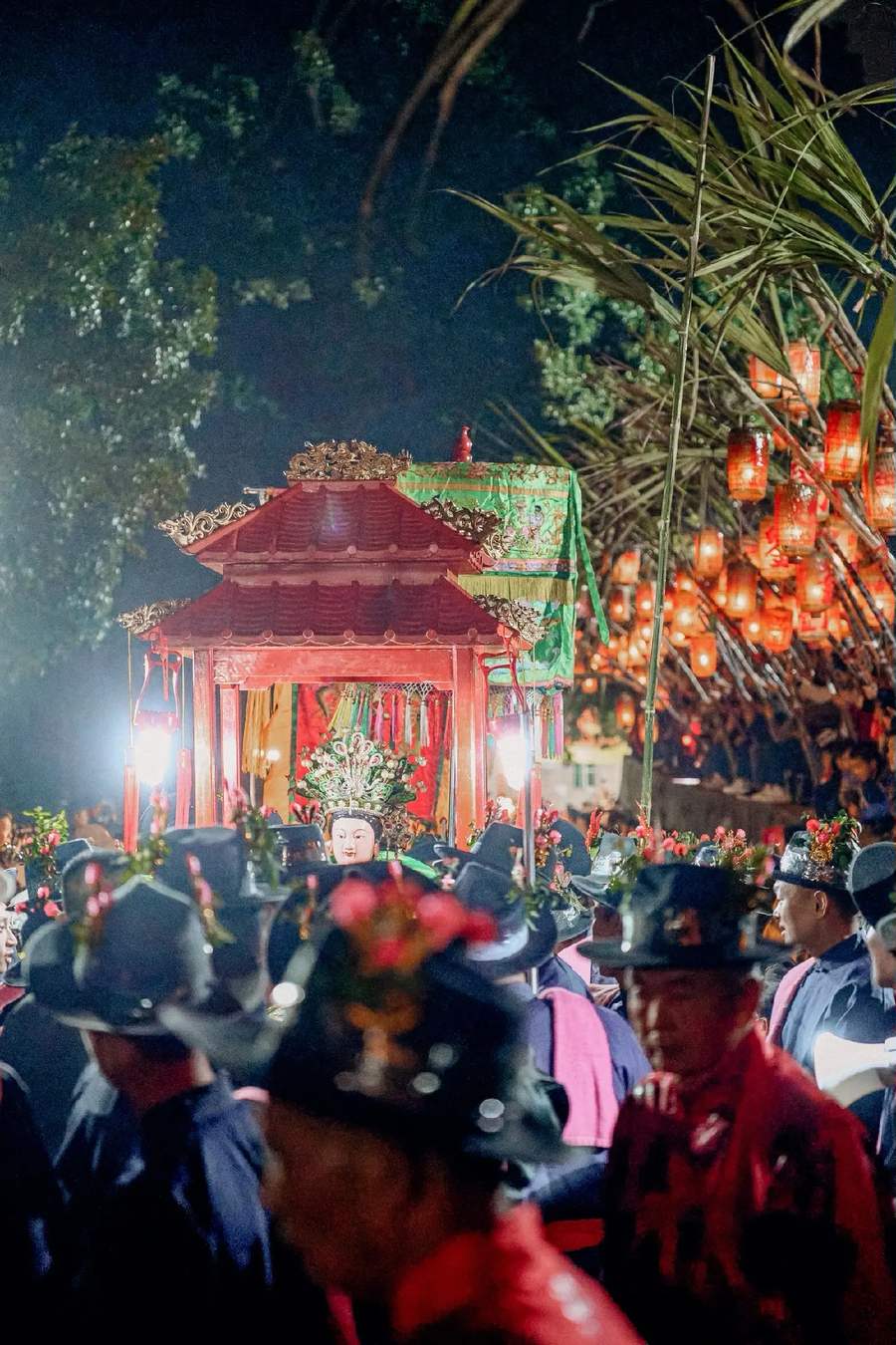 甘蔗横在巷子上方，下面挂满红灯笼，神轿穿行