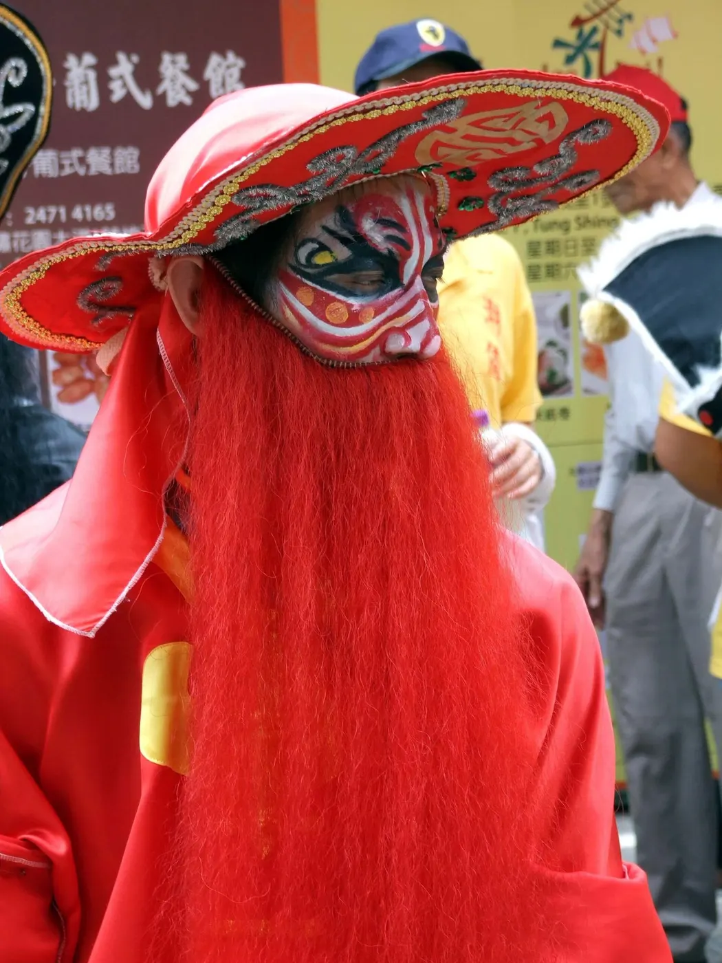红脸红须的脸谱,宽檐笠压到眉上