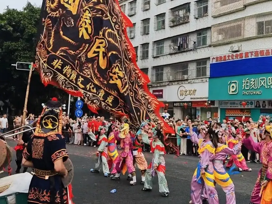 街心一面写着国泰民安的横旗在前,队伍随后跟进