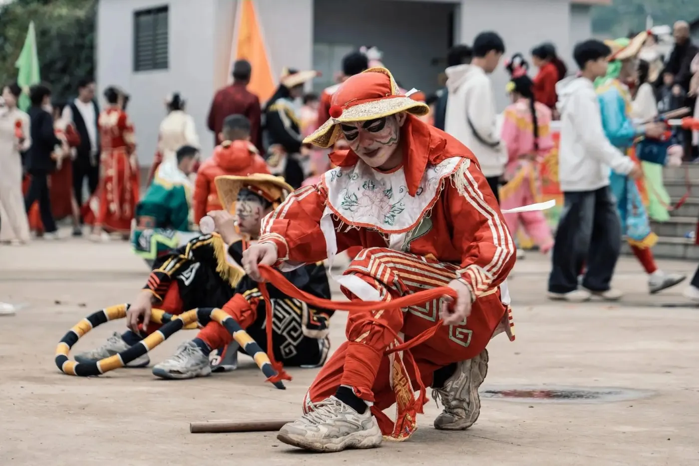 英歌队员坐在广场边休息，槌放在地上